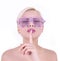 Young woman in glamour pink glasses with finger on her lips