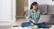 Young woman with glasses doing homework or preparing for an exam studying using a laptop and many books and textbooks