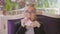 Young woman in glasses sitting at a table in a restaurant wipes her mouth with a paper napkin