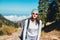 A young woman in glasses travels on foot in a mountainous area