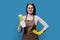 Young woman in gloves apron with organic detergent on blue background