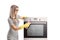 Young woman with gloves cleaning an oven