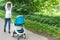 Young woman goes in for sports in park with baby in pram