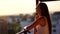 Young woman going on the balcony watching the sunset, middle shot