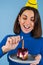 Young woman in golf on a blue background celebrates a birthday