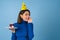 Young woman in golf on a blue background celebrates a birthday