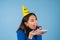 Young woman in golf on a blue background celebrates a birthday