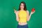 Young woman in good shape holding green cucumber and red salad pepper in hands and thinking about choice.Healthy food Lifestyle Di