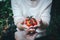 A young woman is grabbing a bunch of tomatoes and send to others hand with carefully