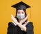 Young woman in graduation gowns with medical mask  and showing stop gesture