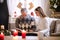 Young woman with grandfather indoors at home at Christmas, looking at photo album.