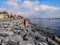 Young woman on a granite shore shoots the landscapes of Marmara sea and Istanbul on the horizon with a smartphone Turkey. Adult
