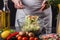 A young woman in a gray apron mixes a salad of Chinese cabbage