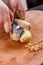 Young woman in a gray apron peeling a ginger root