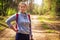 Young woman in green autumn forest. Portrait of cute girl in forest nature. Hikes in woodland. Hiking in wild nature