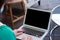 Young woman in green clothes use her finger press on keyboard to waking laptop computer from sleep mode