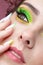 Young woman with green eyes makeup and multi-colored nails manicure