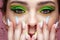 Young woman with green eyes makeup and multi-colored nails manicure