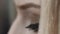 Young woman grey eyes blinking. Black mascara and eyeliner