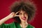 Young woman grimace afro hairstyle red lips fashion red background unaltered