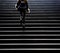 Young woman in grunge outfit climbing up the city street stairs