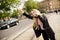 Young woman hailing a taxi on the street in the city