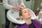 Young woman in hair salon enjoys washing hair