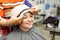 Young woman in a hairdressing salon. The hairdresser puts on the client a thermal cap for lamination and hair treatment