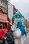 Young woman in Hamburg Christmas parade riding puppet sneaking up on mobile phone user