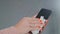 Young woman hand sprays antiseptic on black smartphone