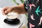 Young woman hand with a vintage colorful swallows blouse stirring a cup of cappuccino coffee latte