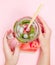 Young woman hands holding freshly squeezed watermelon lemonade of citrus fruits. Female with mason jar full of cold cocktail, mint