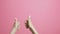 Young woman hands show thumbs up, girl advertises showing gesture class on pink studio background