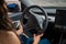 Young woman hands on the steering wheel of a car. Summer trip. Cropped. Travel, lifestyle, transport concept