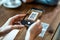 Young woman hands using the smart phone to scan the qr code to select food menu in the restaurant