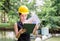 Young woman in hardhat holding clipboard checklist, Quality control concept