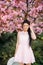 Young woman has enjoy in park with blooming sakura trees