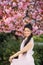 Young woman has enjoy in park with blooming sakura trees