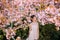 Young woman has enjoy in park with blooming sakura trees