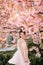 Young woman has enjoy in park with blooming sakura trees