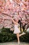Young woman has enjoy in park with blooming sakura trees
