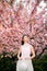 Young woman has enjoy in park with blooming sakura trees