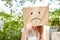 Young woman has face in cardboard box with sad face