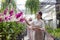 A young woman has fun buying orchids in the store with her mother.