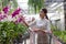 A young woman has fun buying orchids in the store with her mother.