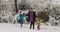 Young woman has fun and dancing with children in a snow park 4k