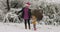 Young woman has fun with her little girl in a snow park in Santa cap 4k