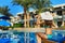 Young woman in hat sitting on a sun lounger near swimming pool, concept time to travel. Relax in the pool summer