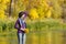 Young woman in the hat is standing on the pier. Autumn sunny day