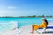 Young woman in hat on a tropical beach relaxing on sunbed